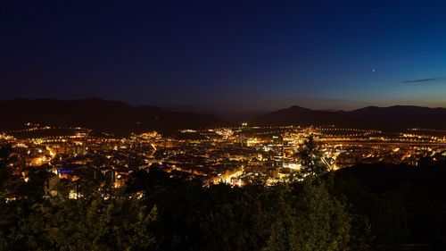 High angle view of illuminated cityscape against sky at night
