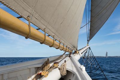 Low angle view of ship sailing on sea against sky