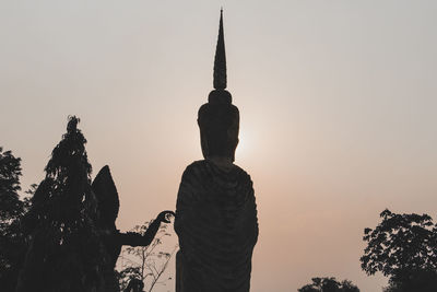 Silhouette of statue against sky during sunset