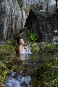 Young woman looking at waterfall