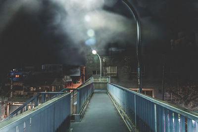 High angle view of illuminated footbridge in city at night