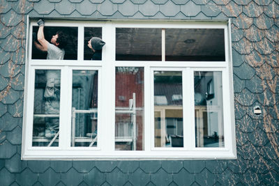 Two men are repairing a plastic window. person