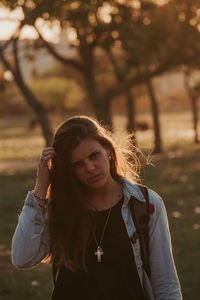 Portrait of woman standing against trees