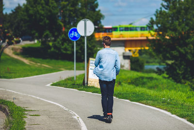 Rear view of woman walking on road