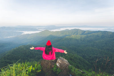 Man with arms outstretched against mountains