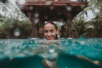 Portrait of smiling woman swimming in pool