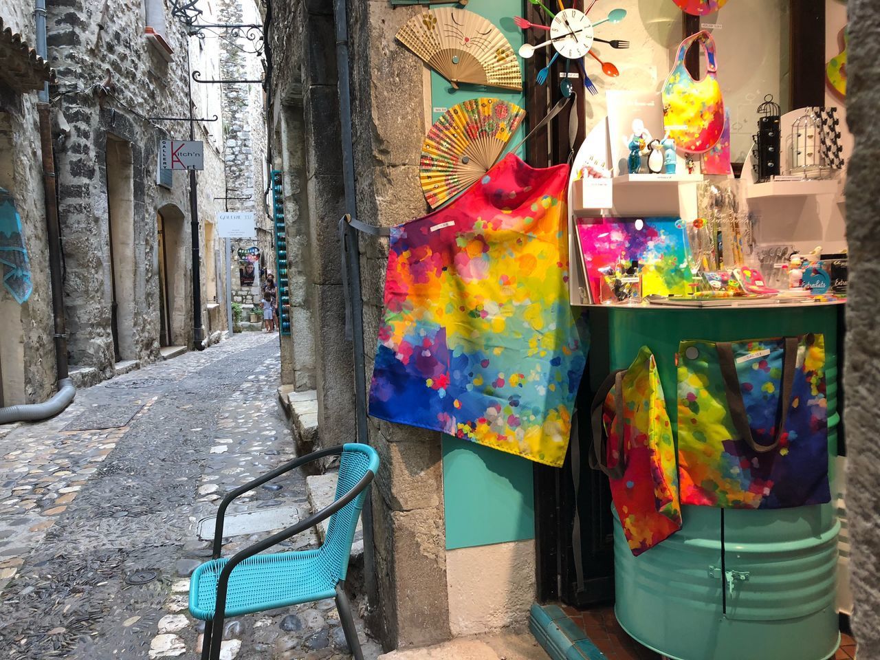 WOMAN HOLDING MULTI COLORED UMBRELLA ON STREET