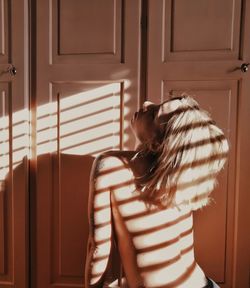 Midsection of woman standing by door at home