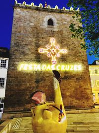 Low angle view of statue against illuminated building