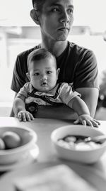 Portrait of son with father by table at home