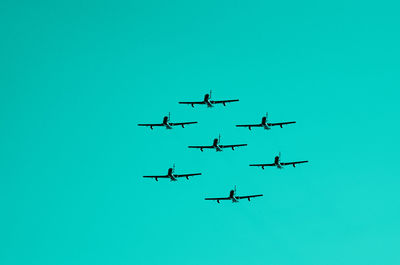 Low angle view of airshow against clear blue sky