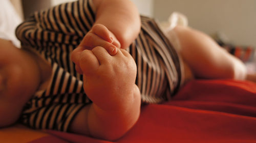 Close-up of baby lying on bed at home