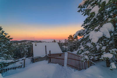 Scenic view of snow covered mountains against sky at sunset