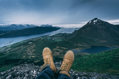 Low section of person on mountain against sky