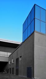 Low angle view of modern building against clear blue sky