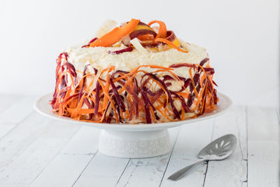 A homemade carrot cake with buttercream frosting and decorated with carrots.