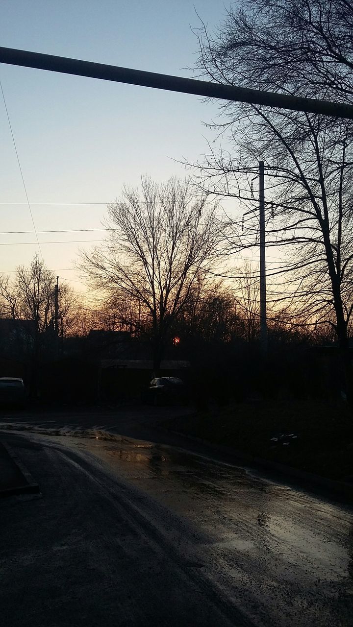 bare tree, tree, sunset, silhouette, clear sky, road, sky, tranquility, electricity pylon, street light, tranquil scene, landscape, branch, street, power line, nature, the way forward, outdoors, no people, transportation