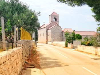 Road amidst buildings against sky