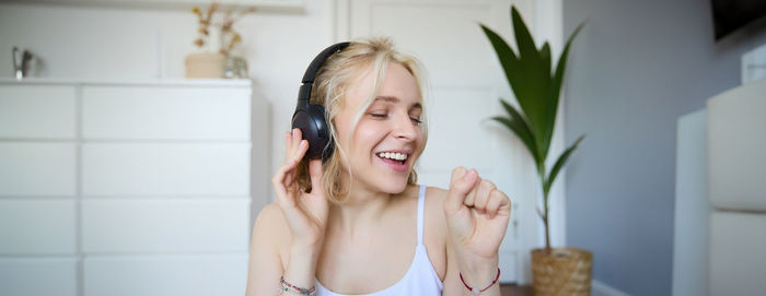 Portrait of young woman applying make-up at home