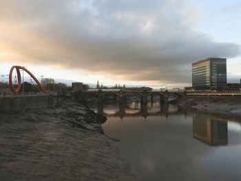 Bridge over water in city against sky