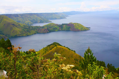 Scenic view of sea and mountains against sky