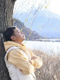 A young man relaxing under the tree against the fuji mountain 
