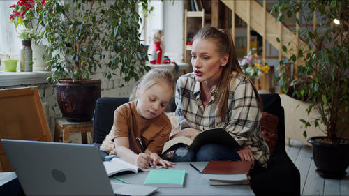 Mother teaching daughter at home