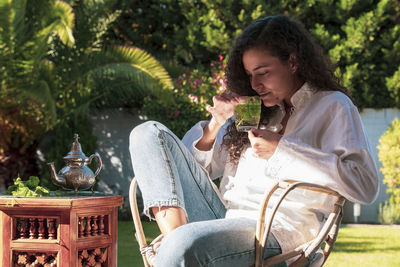 Young woman sitting on table at park