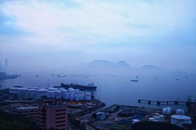 Boats moored at harbor against sky