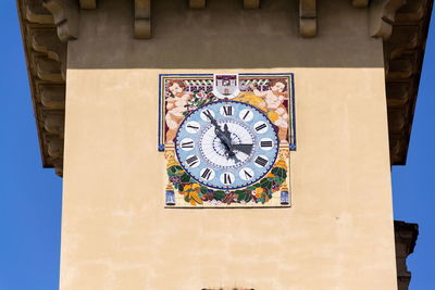 Low angle view of clock on wall of building