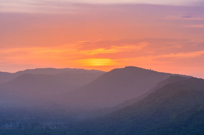 Scenic view of mountains against orange sky