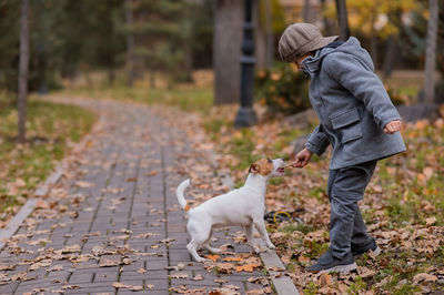 Side view of man with dog on footpath