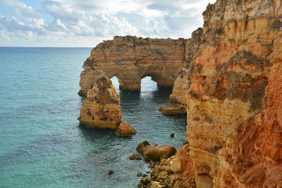 Rock formations by sea against sky