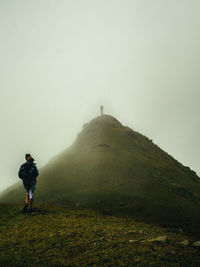 Man standing on mountain against sky