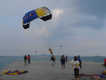 People enjoying parasailing at beach