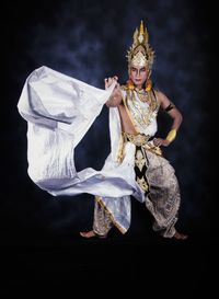 Portrait of woman dancing against black background