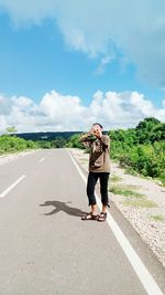 Full length of man standing on road against sky