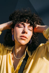 Woman with hands in hair enjoying sunlight