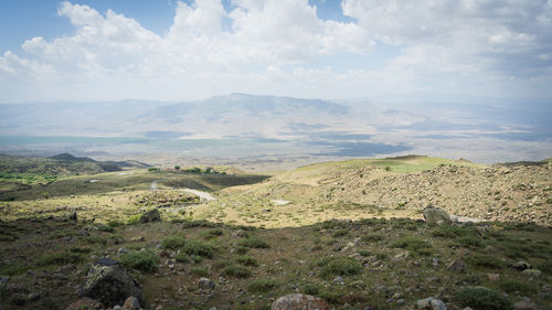 Dry mountainous landscape with small settlement and mountain ranges in backdrop, mount ararat