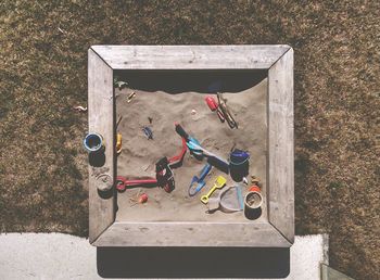 Directly above shot of sandbox with toys at backyard