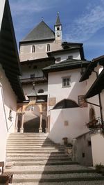 Low angle view of staircase amidst buildings against sky