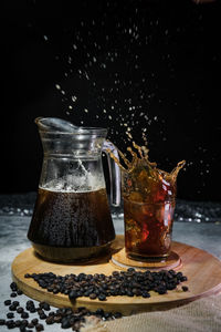 Close-up of glass jar on table against black background