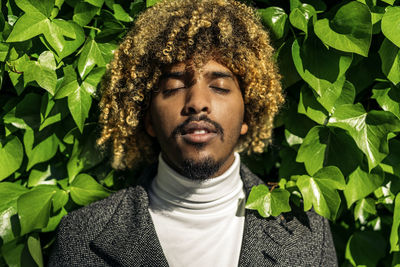 Portrait of young man with leaves outdoors