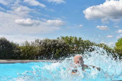 Man swimming in pool against sky