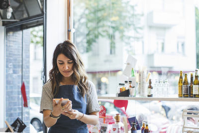 Female employee reading pamphlet while standing in deli