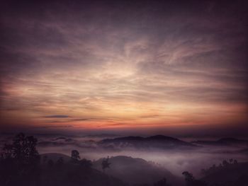 Scenic view of silhouette mountains against sky during sunset