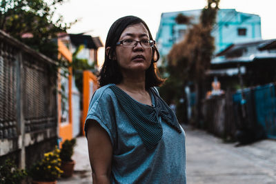 Portrait of young woman looking away in city