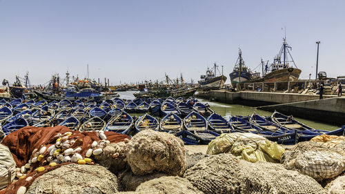 Boats moored at harbor against clear sky