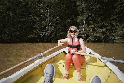 Portrait of smiling woman boating on lake