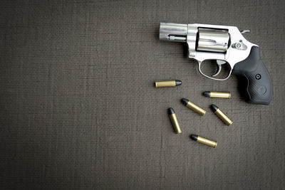 Directly above shot of pistol and bullets on table